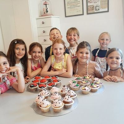 Geburtstagbackparty bei Con Festi, die Kinder dekorieren Cup Cakes