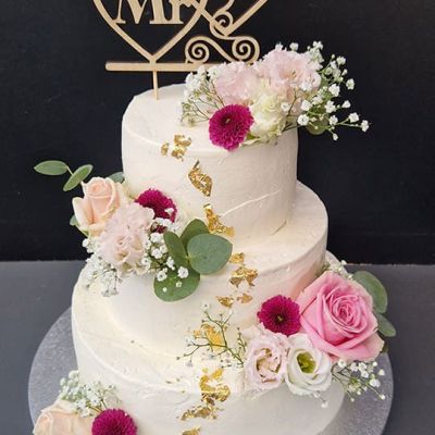 3-stöckige Hochzeitstorte mit weißer Creme, Blumen und Holzschilder Mr & Mrs