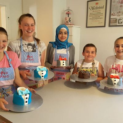 Torte dekorieren als Anzug mit Fliege im Kinderbackkurs bei Con Festi