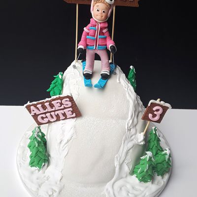 Torte mit Skifahrerin auf Berg