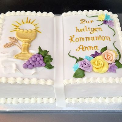 Torte zur Erstkommunion als Buch mit Kelch, Trauben und Blumen