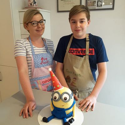 Mutter und Sohn backen Miniontorte