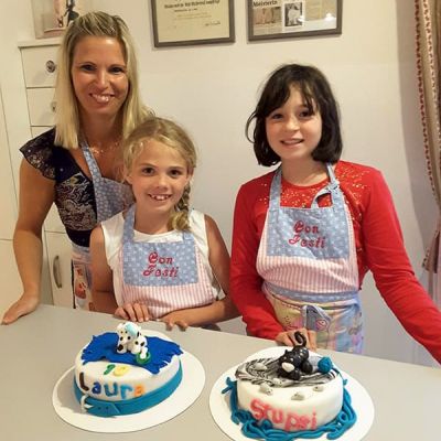 Mutter und Kinder dekorieren eine Torte mit Haustieren bei Con Festi in Völs