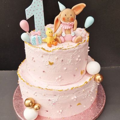 Rose Geburtstagstorte mit einem modellierten Hasen und einem Kücken zum 1. Geburtstag