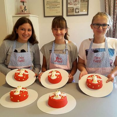 Torte mit rotem Fondant eindecken und mit einer weißen Eule dekorieren im Kinderbackkurs